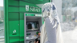 Customer uses an ATM machine near the National Bank of Abu Dhabi headquarters