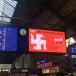 Le drapeau suisse transformé en croix gammée en pleine gare de Zurich, avec l’approbation des CFF