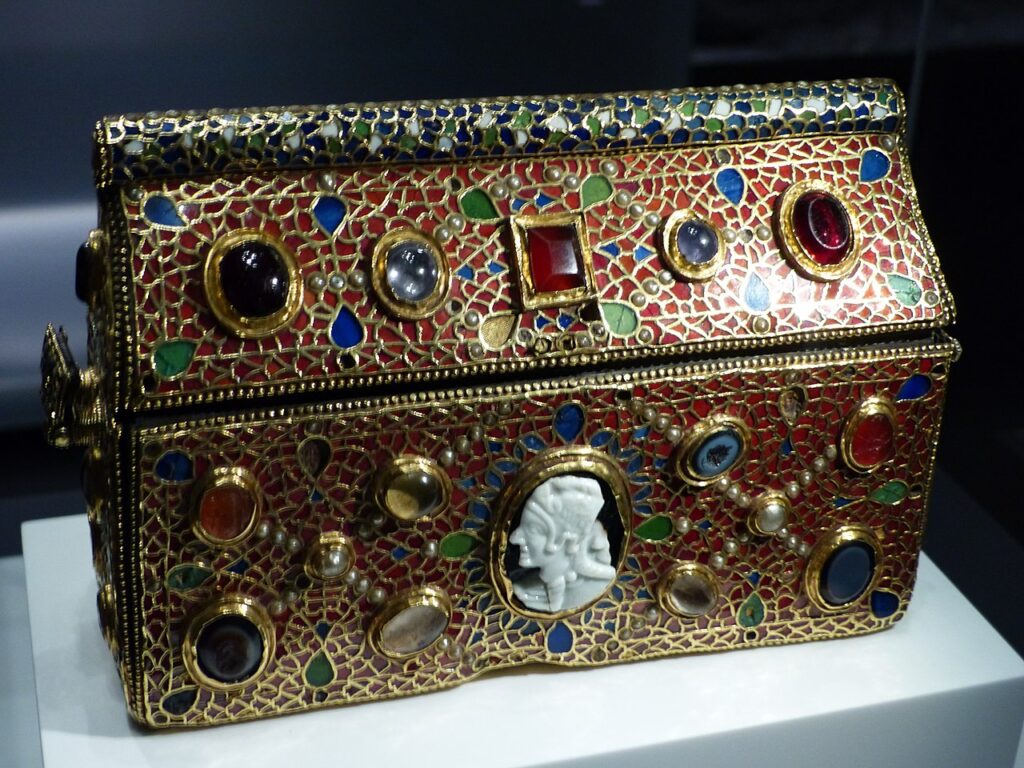 Le coffret-reliquaire de Teudéric est un chef-d'œuvre de l'orfèvrerie mérovingienne (première moitié du VIIᵉ siècle) : sur une âme d'or, un décor de grenats cloisonnés rehaussé de saphirs, de perles et d'un camée antique. L'inscription au revers nomme son commanditaire, le prêtre Teudéric, qui « le fit faire en l'honneur de saint Maurice ». Conservé au trésor de l'abbaye de Saint-Maurice depuis quatorze siècles, il a notamment traversé le pillage sarrasin de 940. Photo : Whgler (CC BY-SA 4.0)