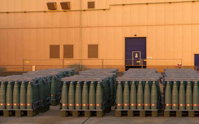 Palettes de munitions d'artillerie de 155 mm dans la cour d'une usine d'armement. Photo : Mike Mareen (Adobe Stock)